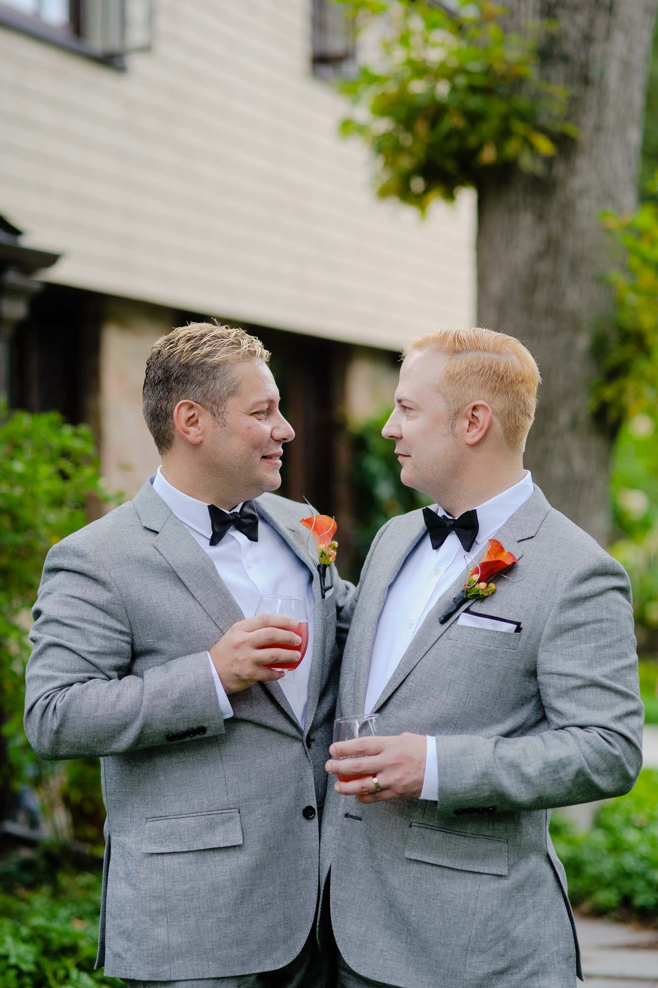 MA Backyard Gay Wedding Grooms Holding Cocktails Drinks